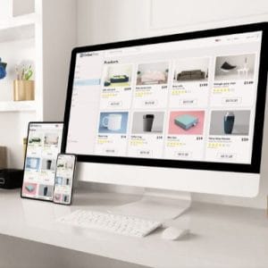 a computer and a phone on a desk showing responsive websites