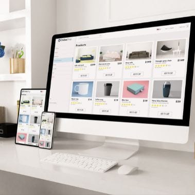 a computer and a phone on a desk showing responsive websites